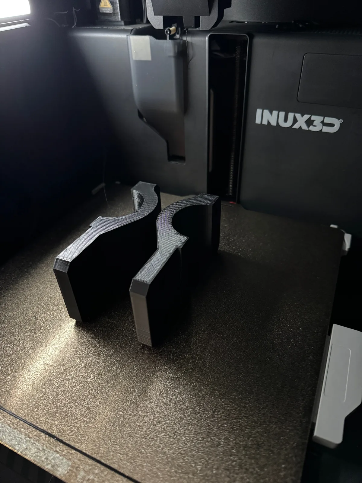 Pair of identical 3D printed clamps fresh off the print bed
