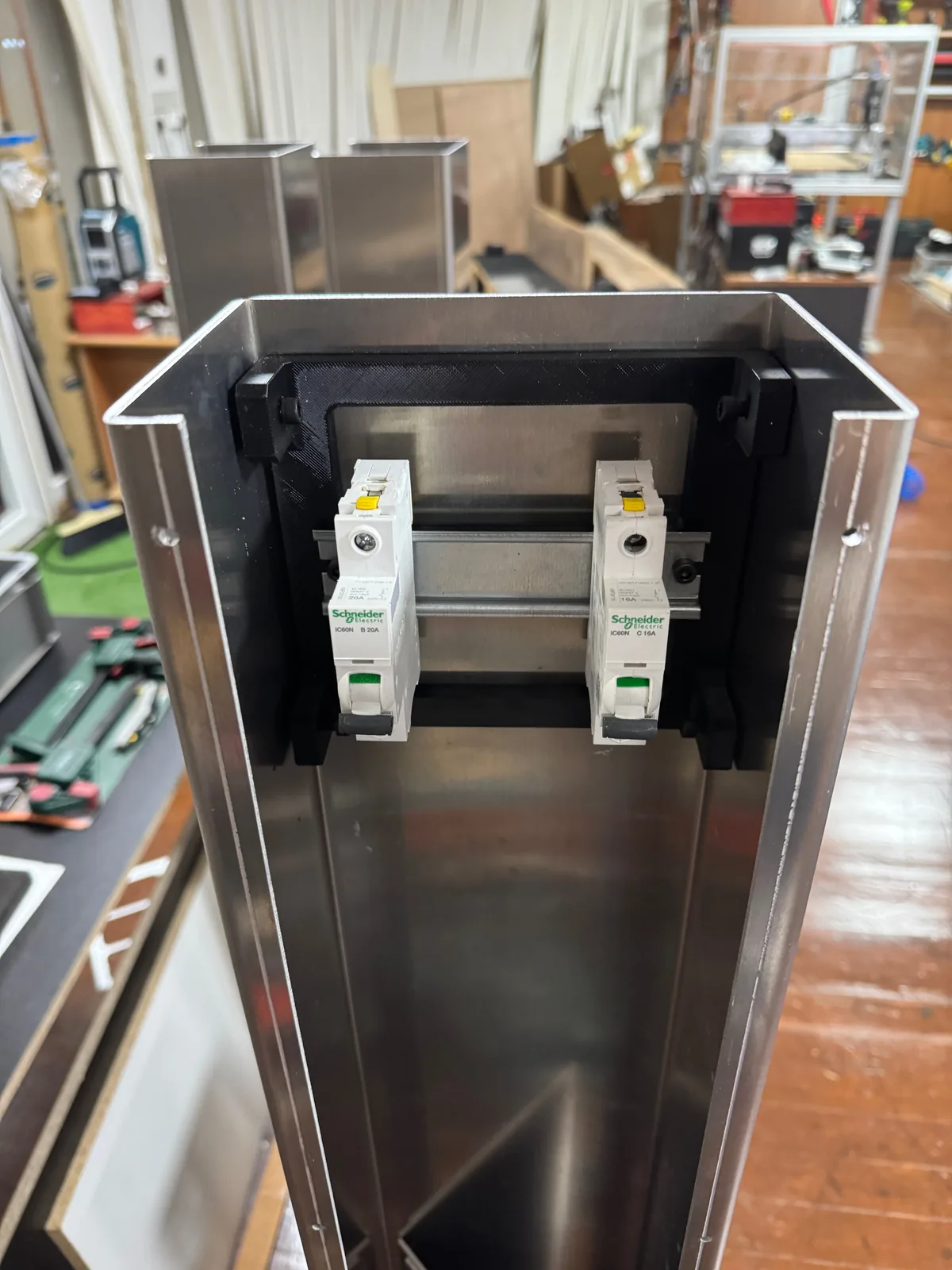 Custom 3D printed DIN rail mounting frame with circuit breakers installed inside an aluminium enclosure