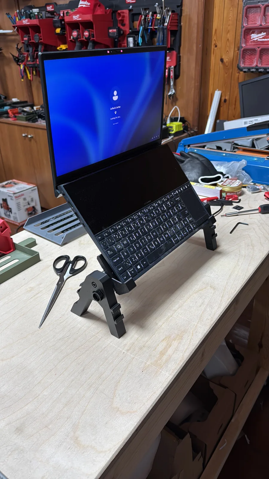 Custom designed 3D printed stand holding a dual-screen laptop on a workshop bench
