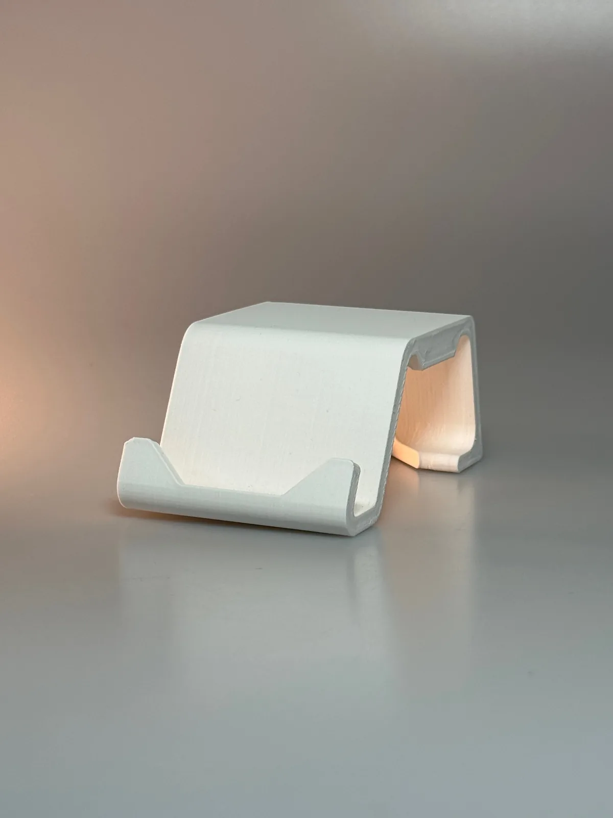 White 3D printed phone stand, in-house product design on seamless background
