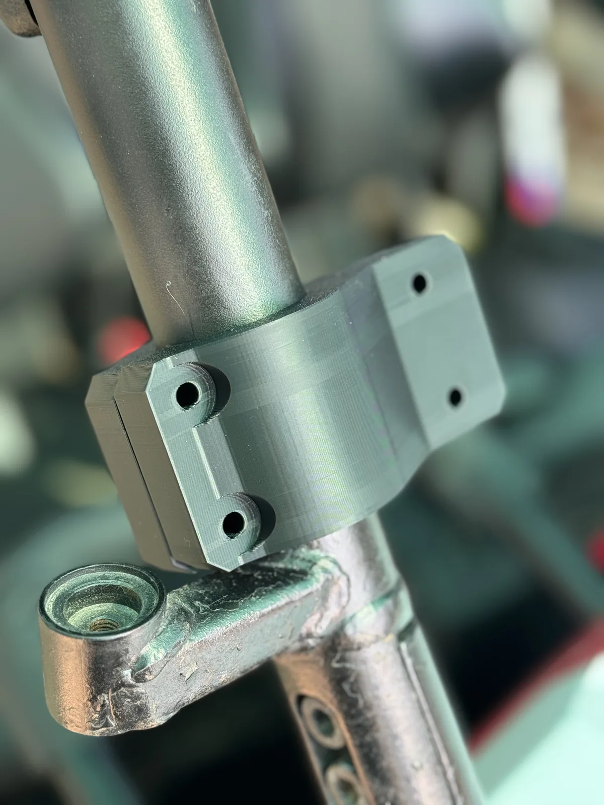 3D printed clamp seated on a steel tube with bolt fixing points