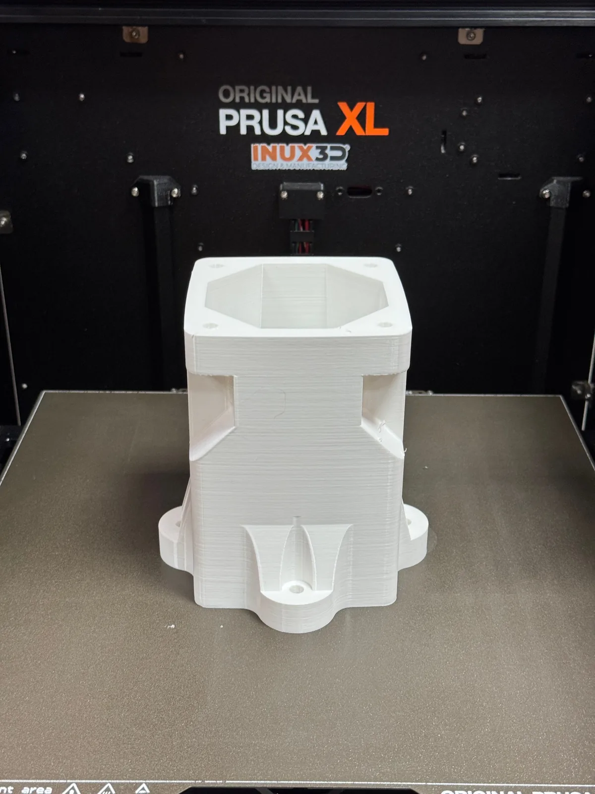 White 3D printed structural bracket prototype with mounting flanges and bolt holes